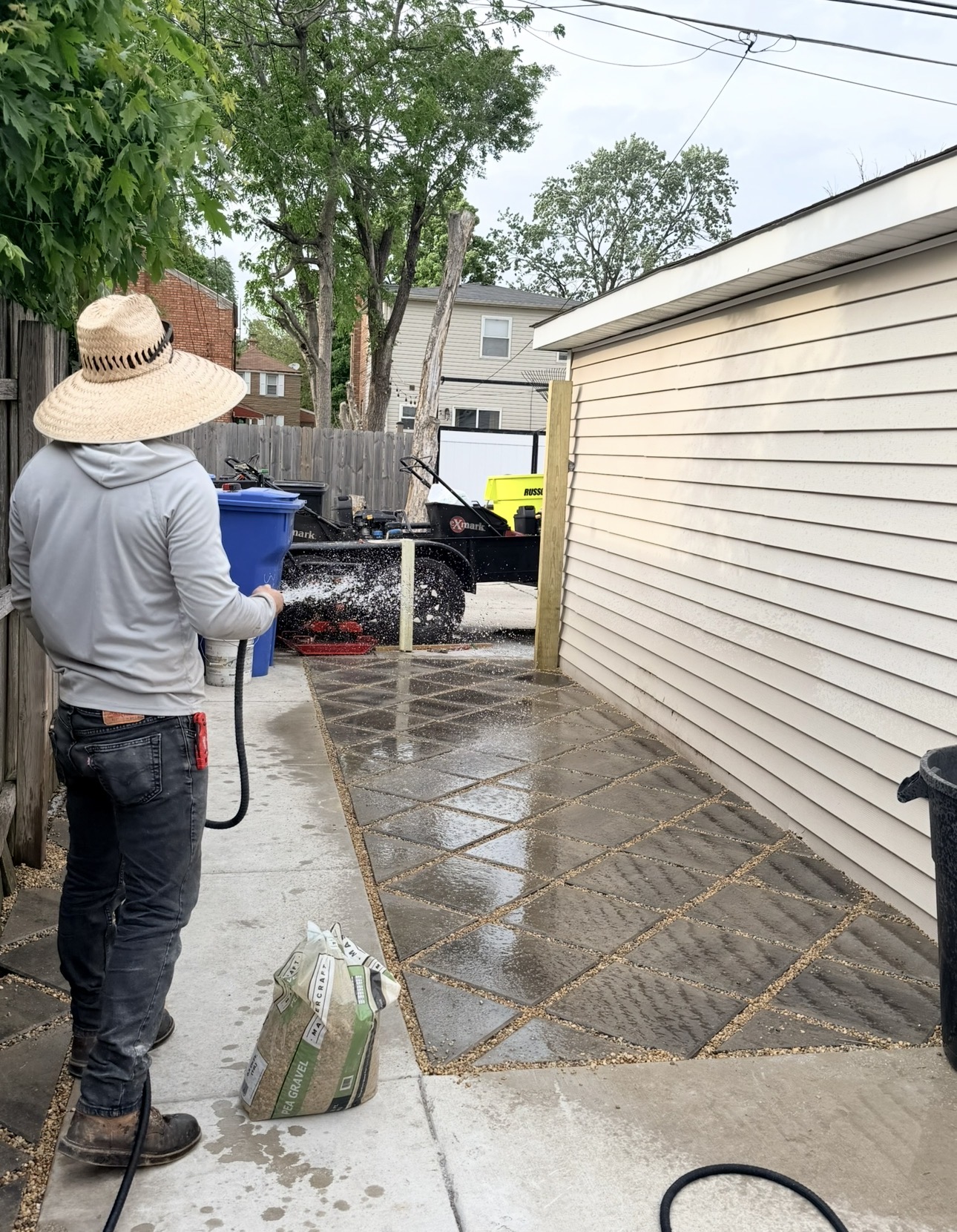 EZA Landscaping crew cleaning a newly installed backyard paver area