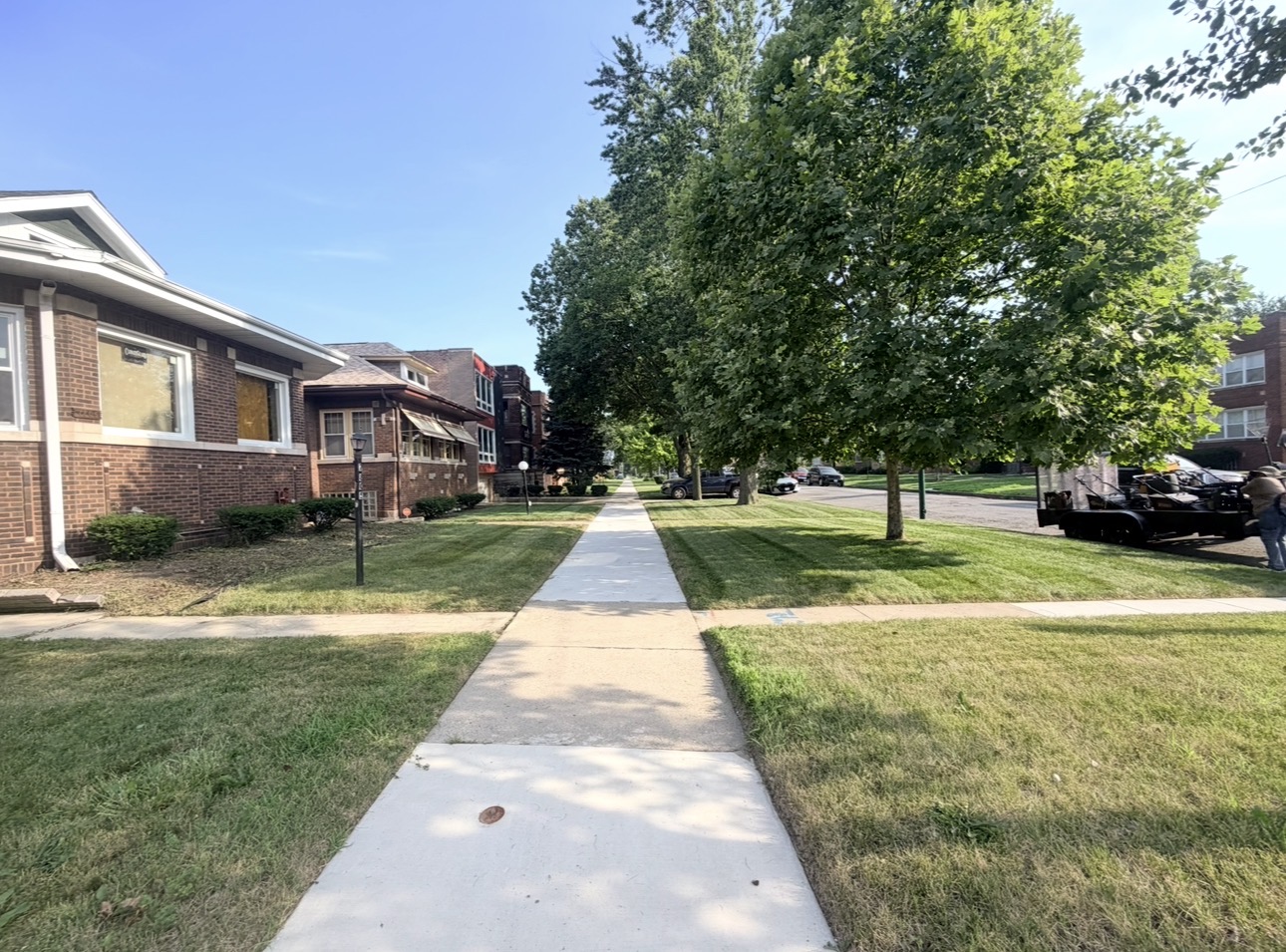 Long stretch of neatly maintained neighborhood lawns by EZA Landscaping