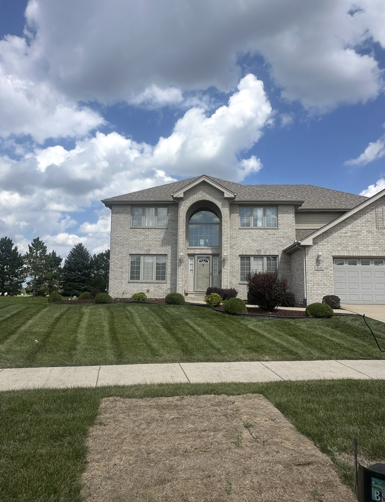 Freshly striped residential lawn maintained by EZA Landscaping